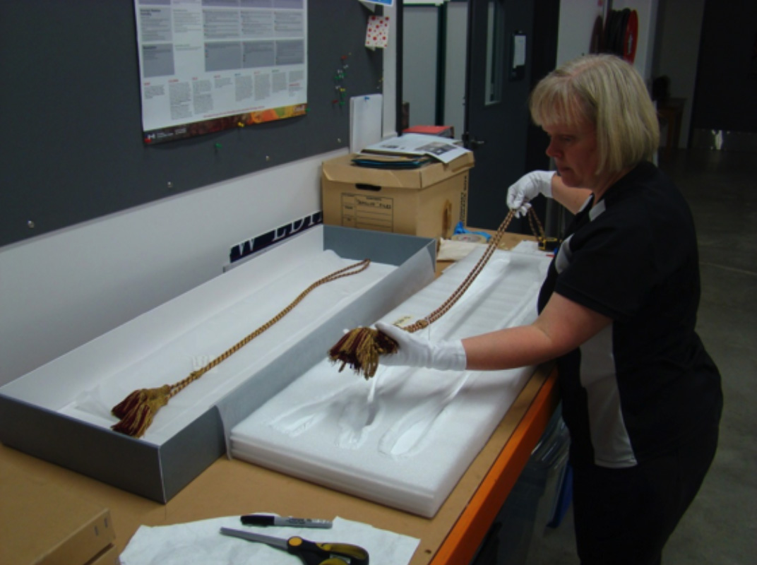 Registrar Claire Orbell packing the cord and tassels from the colours 